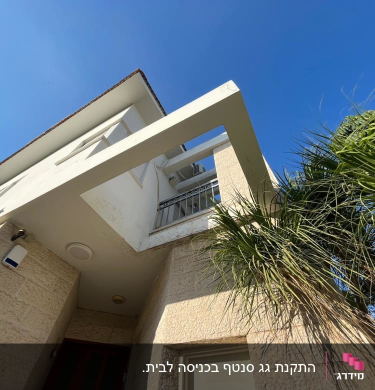 צמחייה ירוקה ליד מבנה לבן עם שמיים כחולים